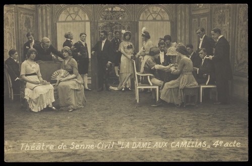 Download the full-sized image of French or Belgian prisoners of war, some in drag, posing on stage during a crowded scene of "La dame aux camélias"; at Sennelager prisoner of war camp in Germany. Photographic postcard, 191-.