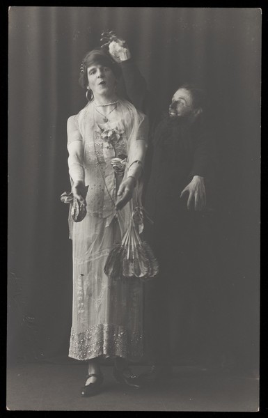 Download the full-sized image of Ralph Mellor in drag and another actor perform a scene in Trilby. Photographic postcard by L.S. Langfier, 192-.