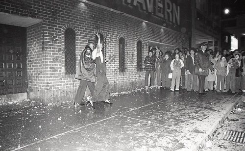 Download the full-sized image of Police Escorts Waving Person Outside of St Charles Tavern