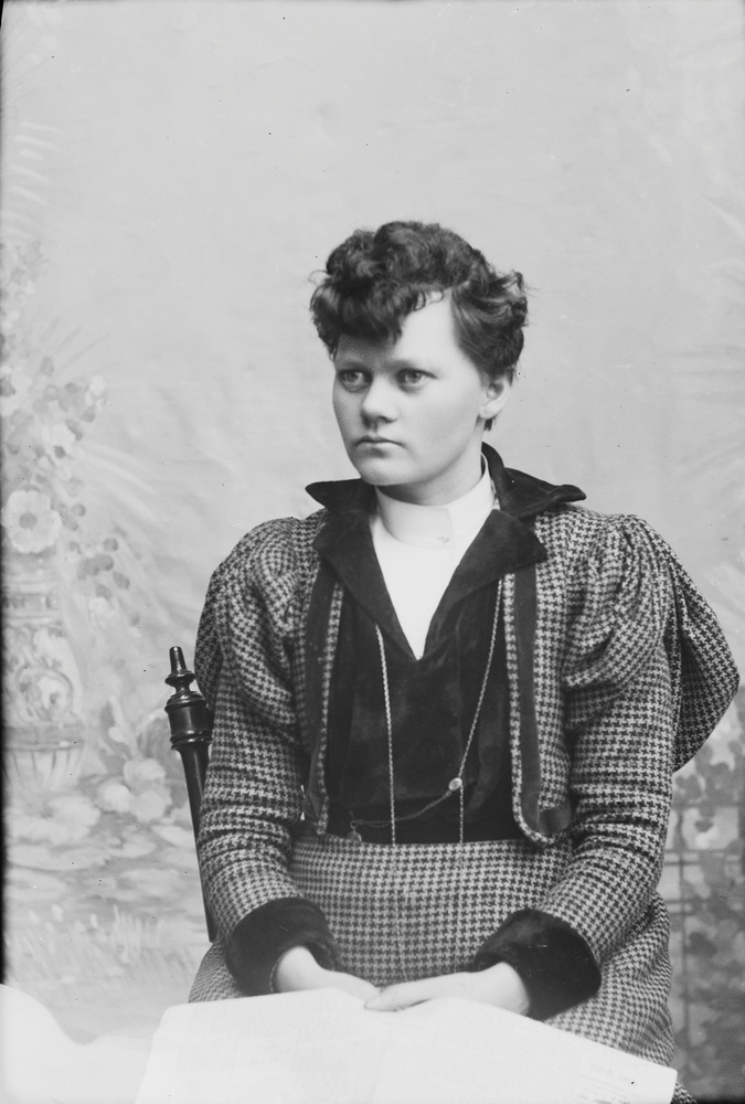 Download the full-sized image of Marie Høeg Sitting in a Chair Holding a Book